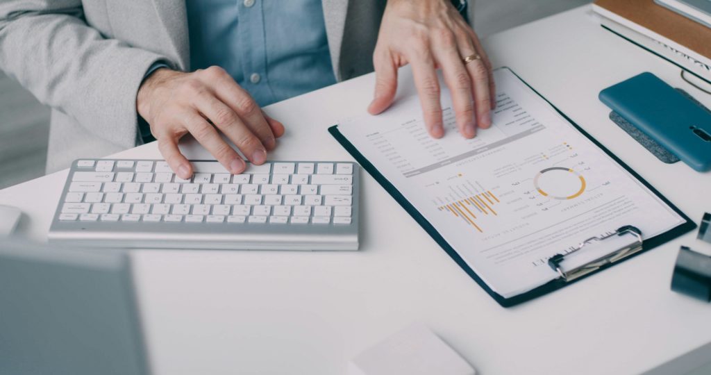 Manos en teclado y documentos