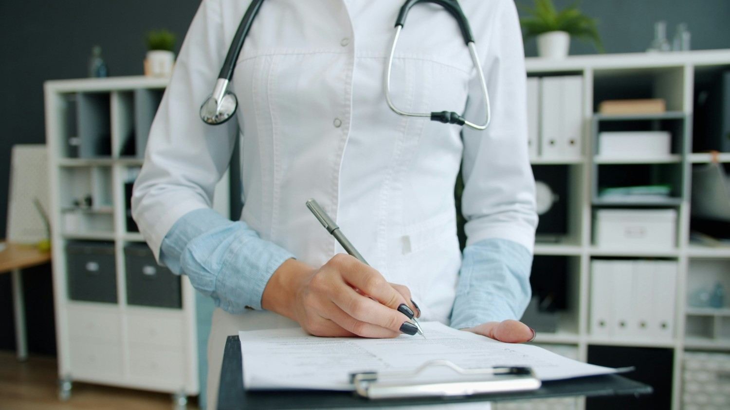 Médico escribiendo en formulario